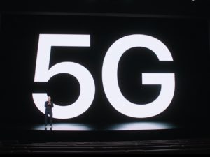 Tim Cook in from of a 5G sign at the Apple iPhone event